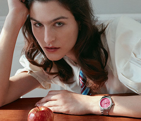 Woman in a white shirt wearing a pink-dial Vivienne Westwood watch.